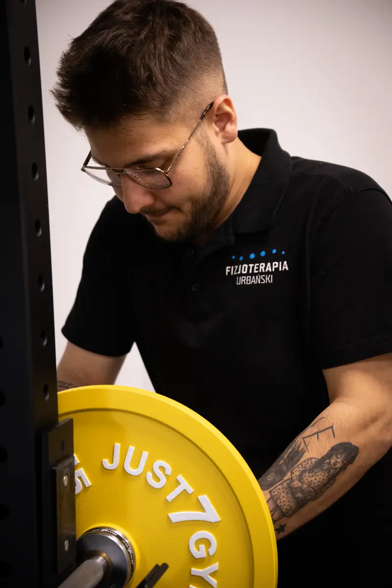 Jakub Gibas przygotowuje sztangę do treningu